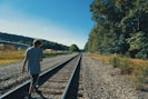 a man standing on a train track next to a forest