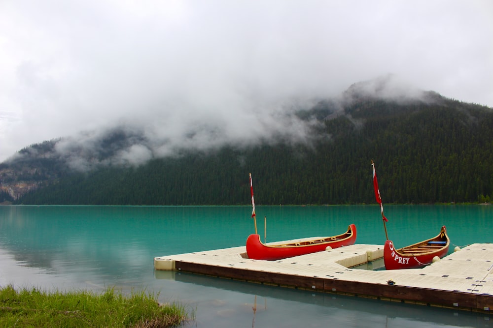 two red boats on body of water