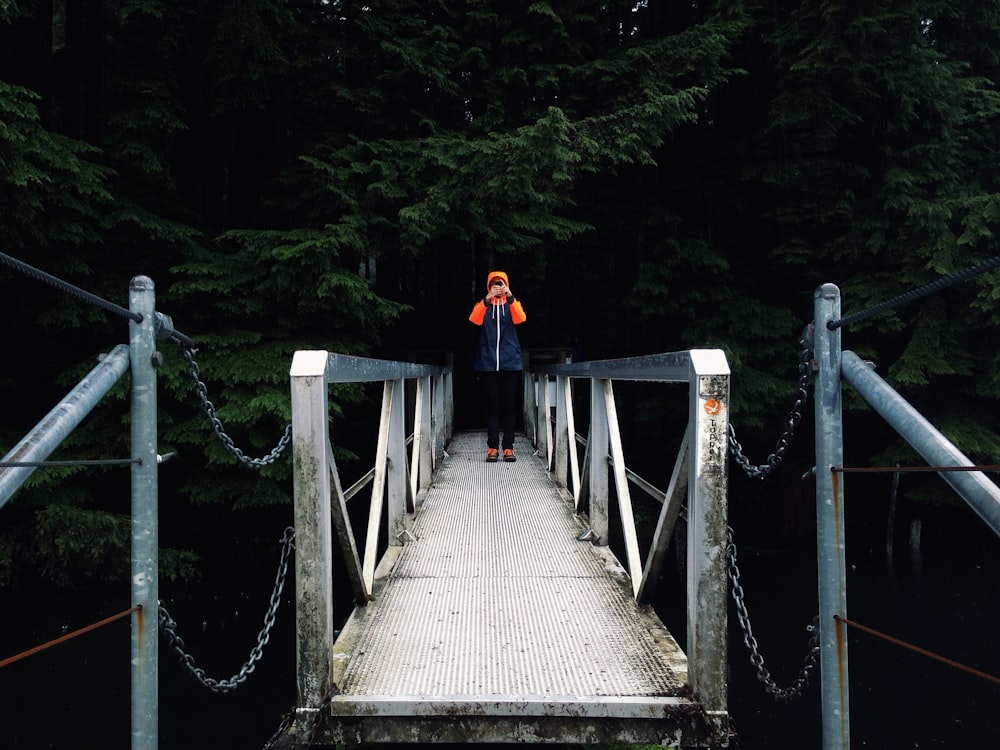 person standing on a bridge during day time