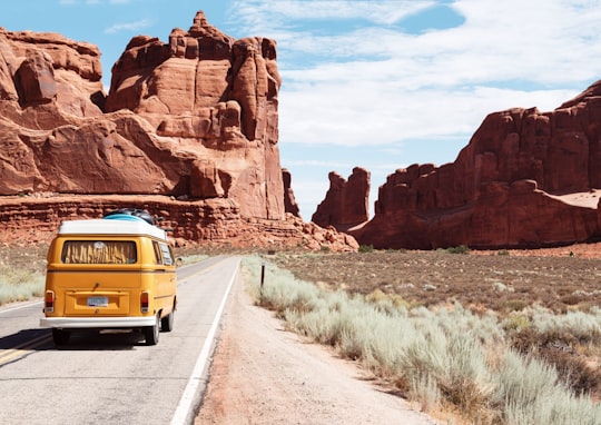 yellow Volkswagen van on road in Arches National Park United States