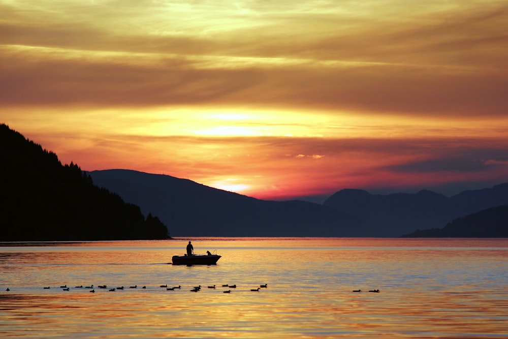 silhouette photography of person standing on boat