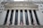 The image features the facade of a grand building with Corinthian columns and a pediment adorned with sculptures. The building is identified as the New York Stock Exchange, with its name prominently displayed. American flags are visible in front of the structure, adding to its formal and historic appearance.