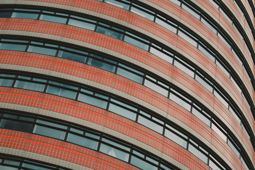 Fotografía de ángulo bajo de edificios de vidrio de hormigón rojo y transparente