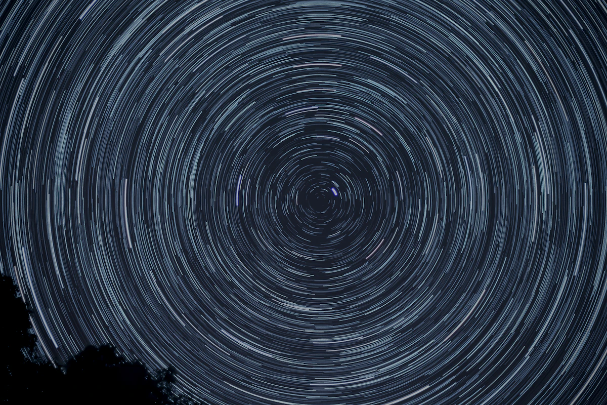 A shooting star over dark hills