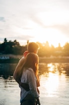 couple walking on lake side watching sunset close-up photo