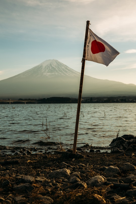 Japan flag mounted near on body of water in Lake Kawaguchi Japan