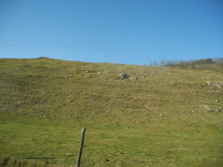A wide open plot in Pen with a backdrop of hills and open fields.