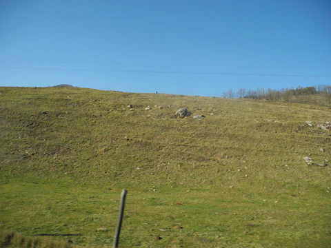 A wide open plot in Pen with a backdrop of hills and open fields.