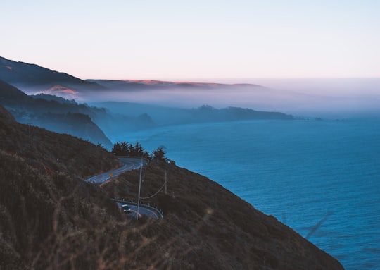 body of water and road hills surrounded by fogs in Big Sur United States