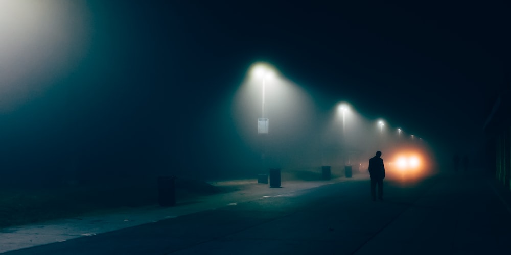 a person walking down a street at night