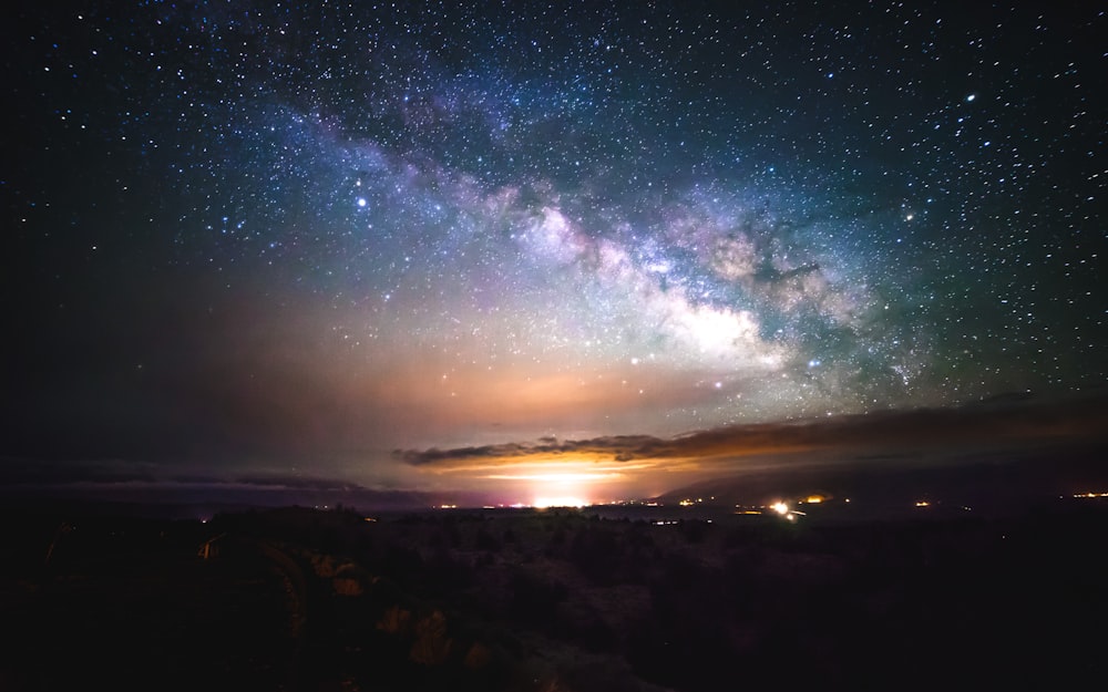 a view of the night sky from a hill