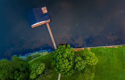 Aerial view of a sleek floating home surrounded by lush greenery and water.