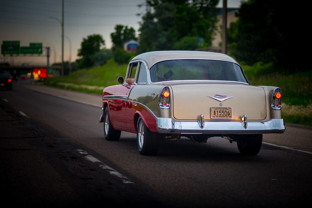 a classic car driving down the road at night