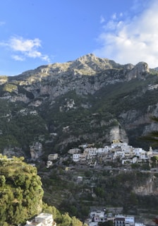 A quiet mountain village nestled among lush green hills under a clear blue sky.