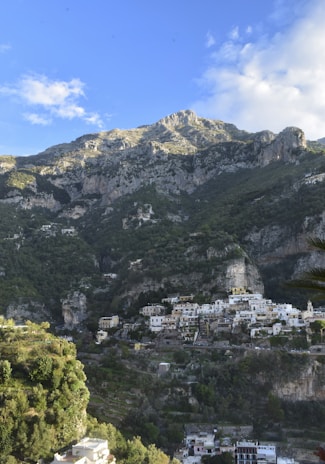 A quiet mountain village nestled among lush green hills under a clear blue sky.