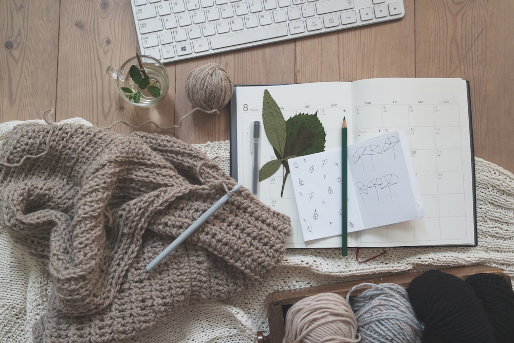 black pencil on white card beside brown knit textile