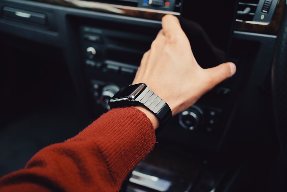 selective focus photography of person with smart watch driving car