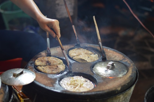 A commercial chapati making machine in action, rolling dough into perfect circles.