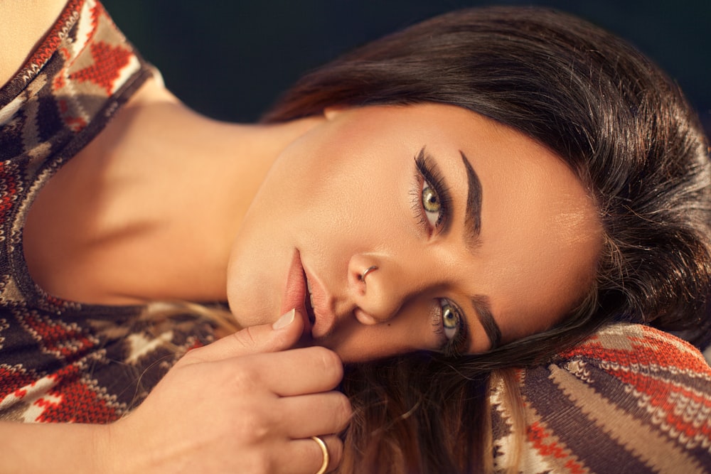 woman wearing red, white, and black aztec top