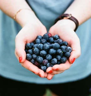 person showing blue berries