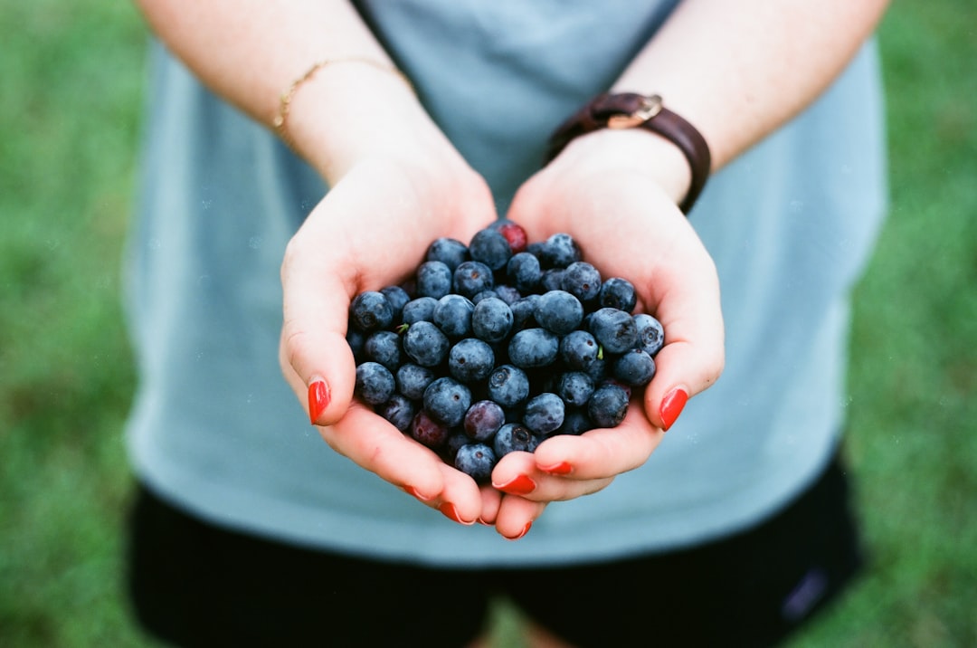 person showing blue berries, Handful of Blueberries