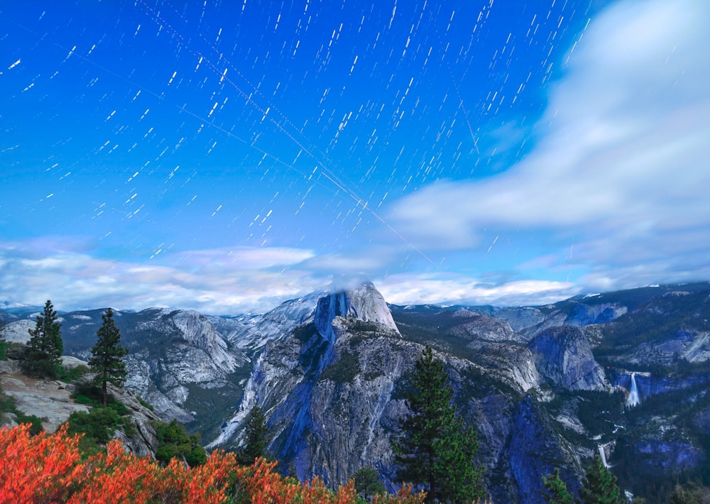 gray rock mountains under white and blue cloudy sky