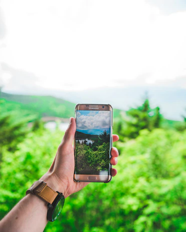Close-up of hands holding a smartphone displaying an augmented reality tour of an eco-destination.
