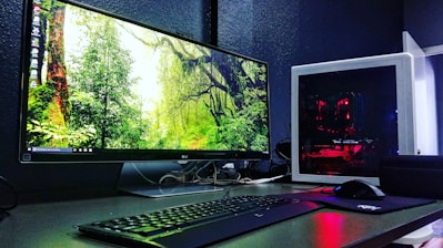 A sleek modern computer setup with a vibrant screen and ergonomic keyboard on a wooden desk.