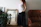 Photo of a happy woman standing next to a newly installed large mirror in a stylish living room
