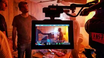Behind-the-scenes view of a film production set with crew coordinating complex logistics.
