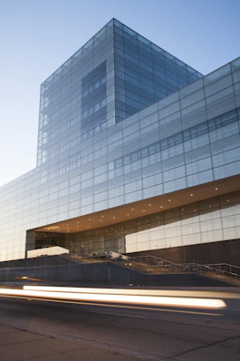 modern glass building at dusk with light trails