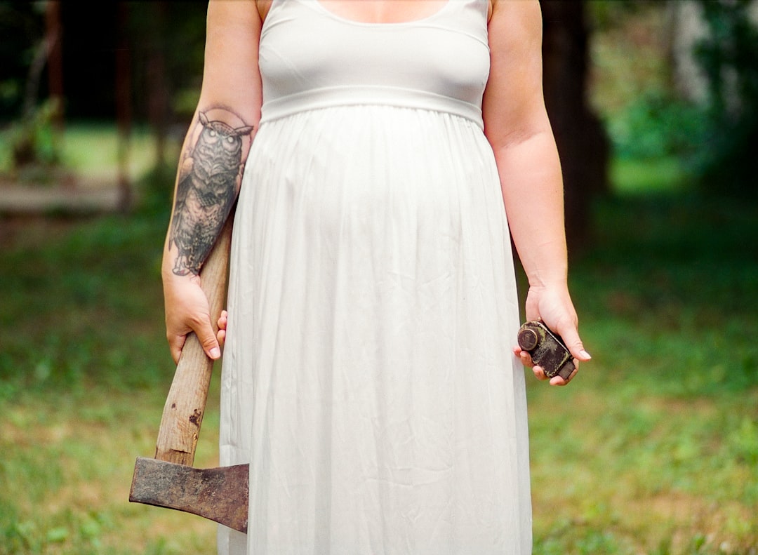 woman in white dress holding axe during daytime