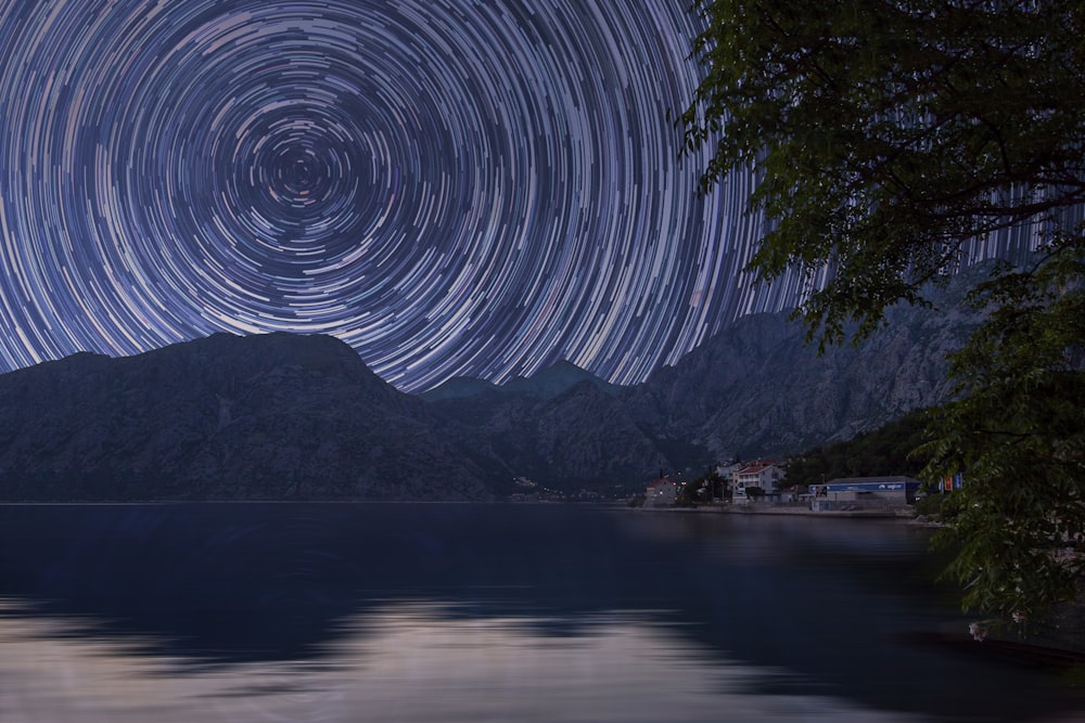 bodies of water near mountain at starry night