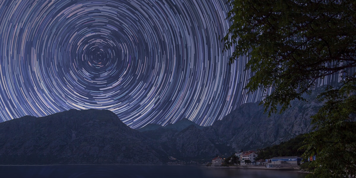 bodies of water near mountain at starry night