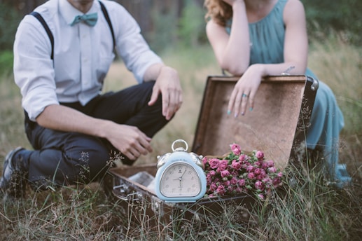 man in white dress shirt sitting on brown wooden bench