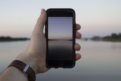 A serene landscape with a gamer immersed in their device.