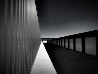 A well-lit, secure storage facility with rows of locked units and visible CCTV cameras at dusk.