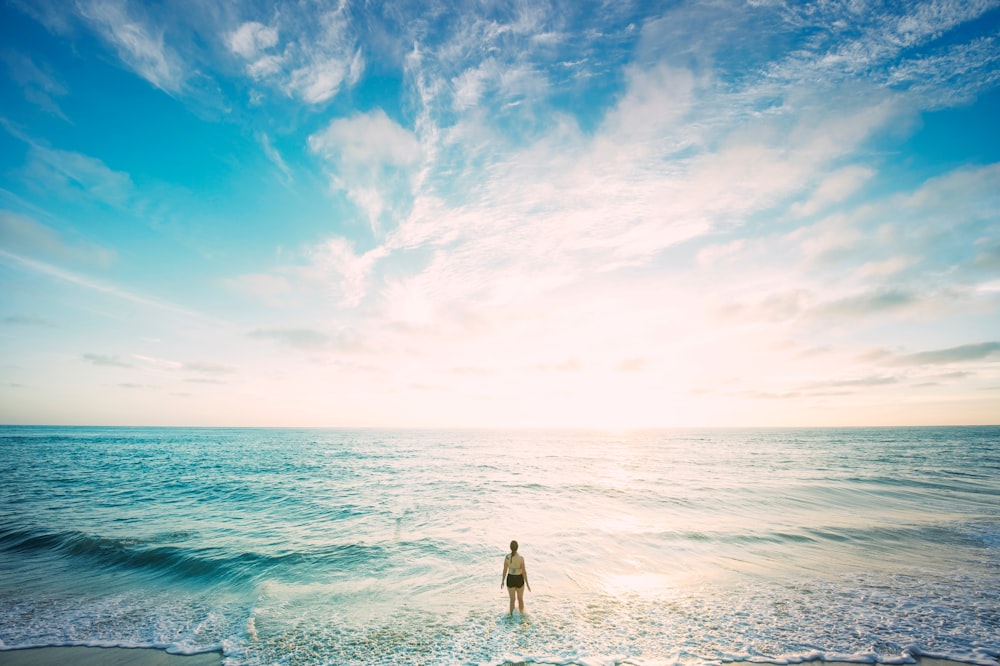 femme sur la mer devant le soleil