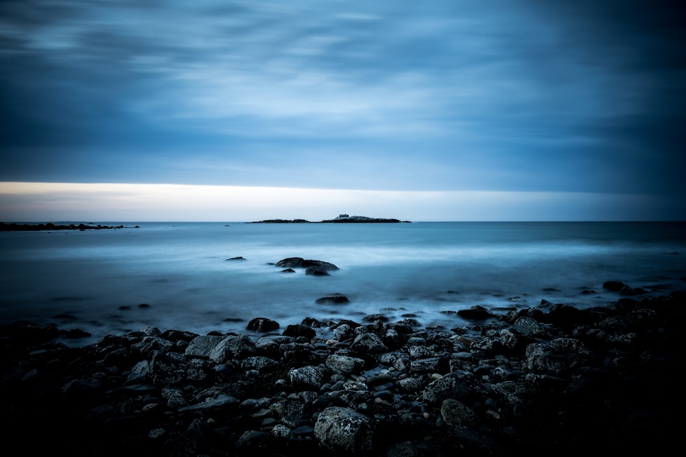 Orilla del mar bajo cielo azul y vista de nubes blancas