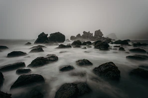 Soft-focus photograph of a misty Cornish coastline at dawn, evoking solitude and calm.
