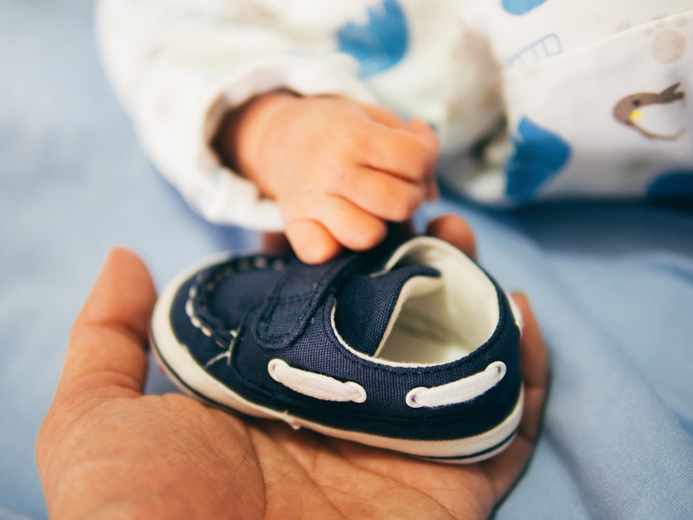 person holding blue boat shoe