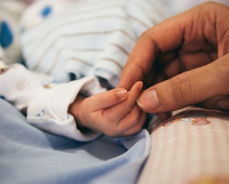 person holding baby's index finger