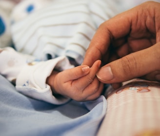 person holding baby's index finger