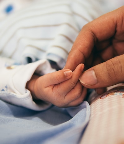 person holding baby's index finger