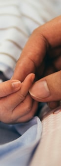 person holding baby's index finger