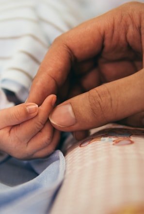 person holding baby's index finger