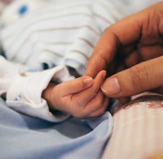 person holding baby's index finger