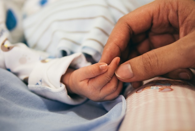 person holding baby's index finger for Dareltebb Specialized Clinics, Benha, Egypt