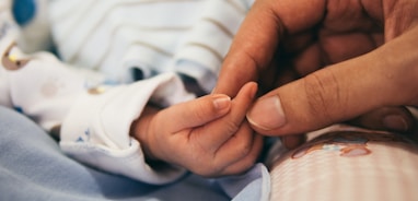 person holding baby's index finger