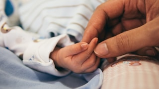 person holding baby's index finger